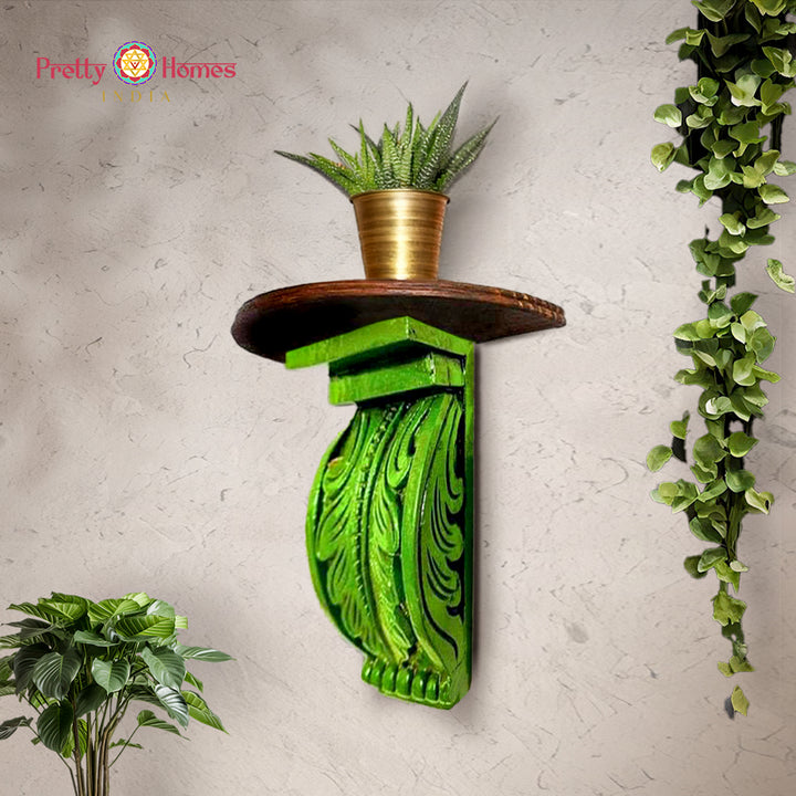 Green hand-painted carved wooden corbel shelf with decorative leaf carving and round top.