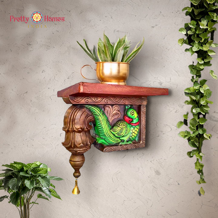 Hand-carved wooden wall corbel shelf with painted green parrot motif and turned finial.