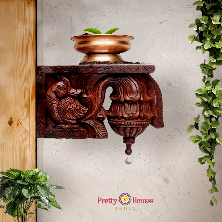 Decorative carved wooden shelf bracket featuring a stylized bird panel and turned finial.