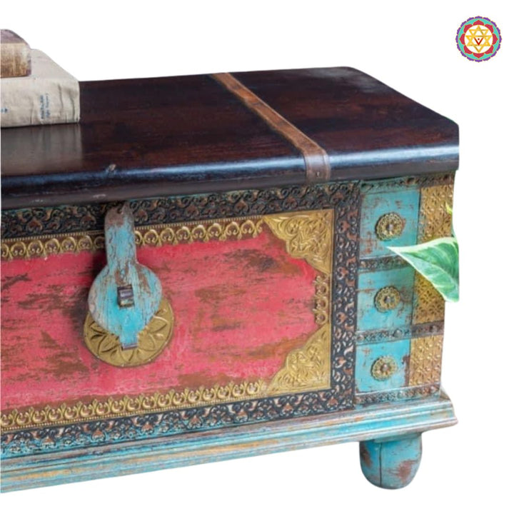 Front view of colorful wooden chest — brass inlay patterns and heritage detailing on red-blue painted surface