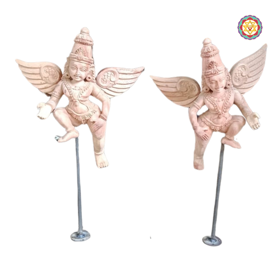 Two primed Gandharva sculptures close-up on white background — carved wings, jewelry motifs, hand-finished wooden angels