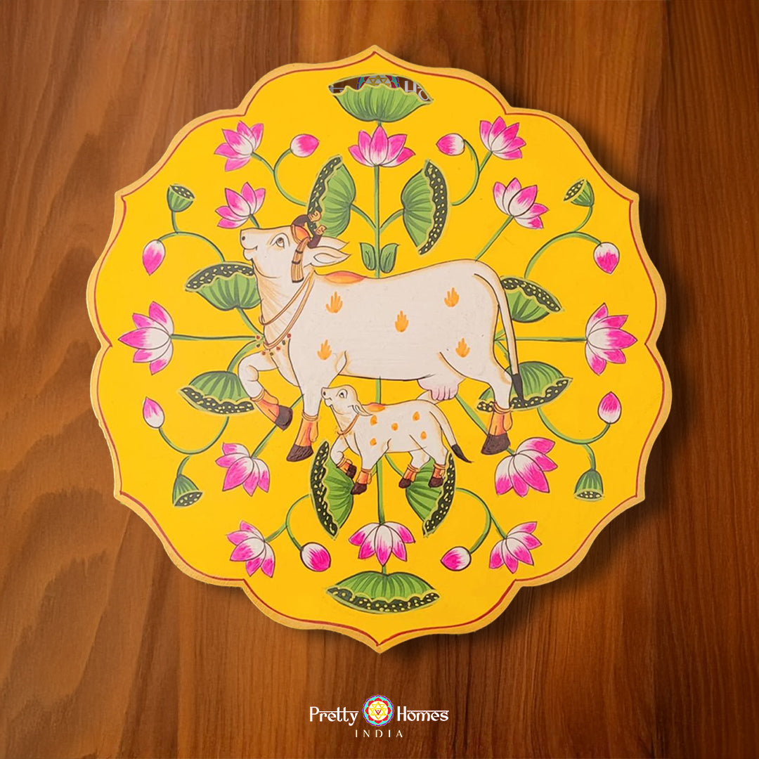 Petal-shaped yellow wooden plate with hand-painted pichwai cow, calf, and lotus pichwai painting. Ideal for pichwai home decor.