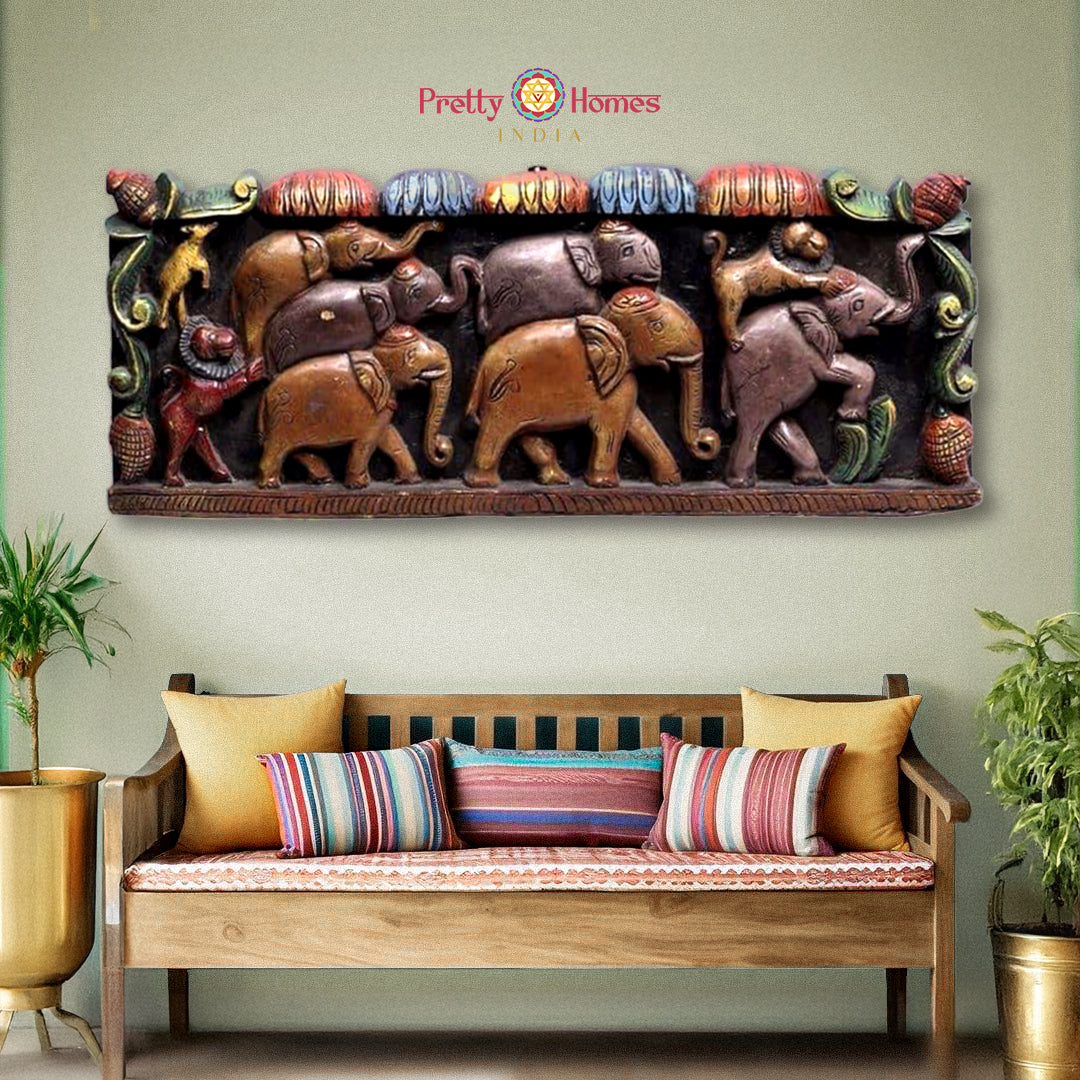 A wall-mounted wooden panel with a series of carved elephants in various poses and colors, providing a vintage finish.