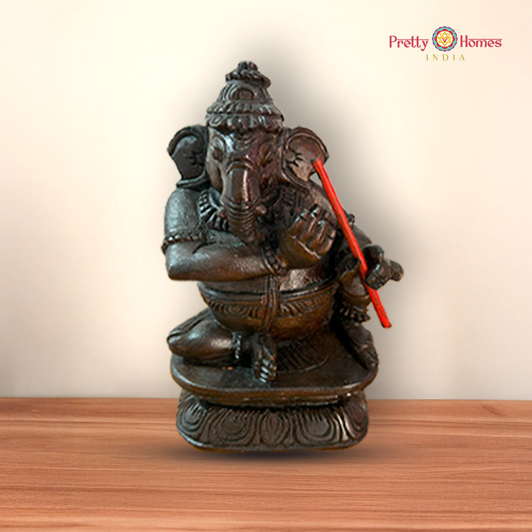 Ganesh figurine playing tabla with intricate detailing and antique polish finish