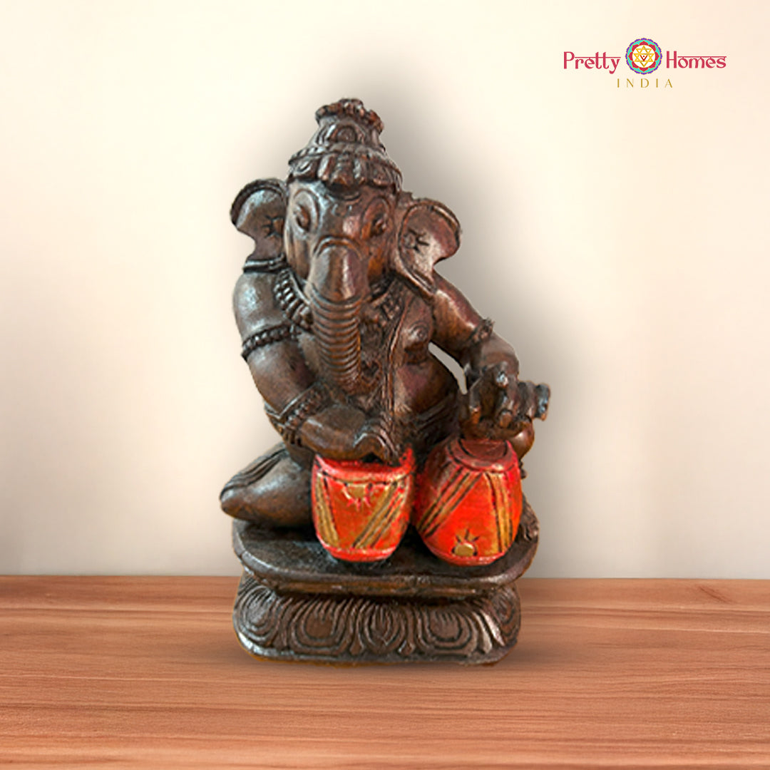 Close-up of Ganesh idol playing flute with detailed ornaments and attire