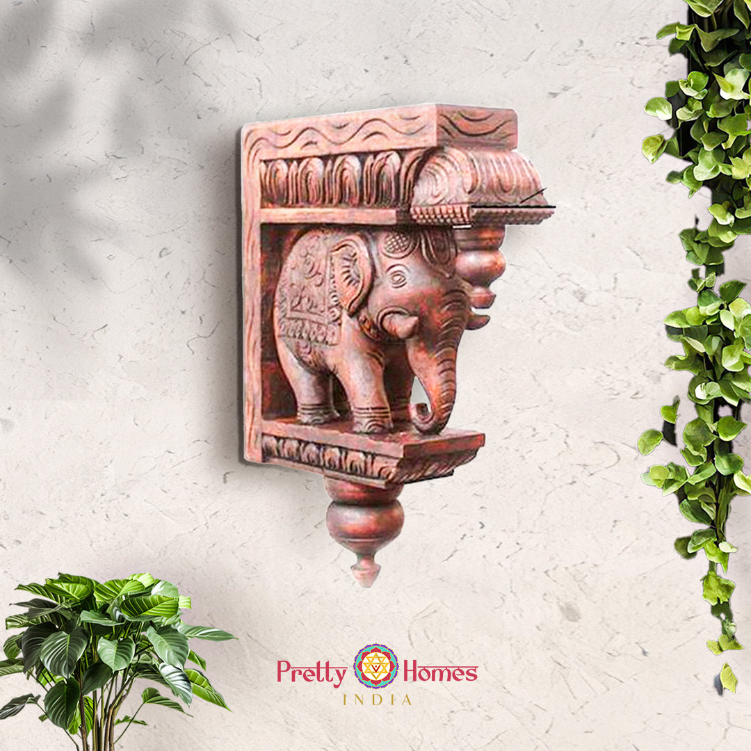 Hand-carved brown wooden elephant wall bracket with ornate detailing and turned finial.