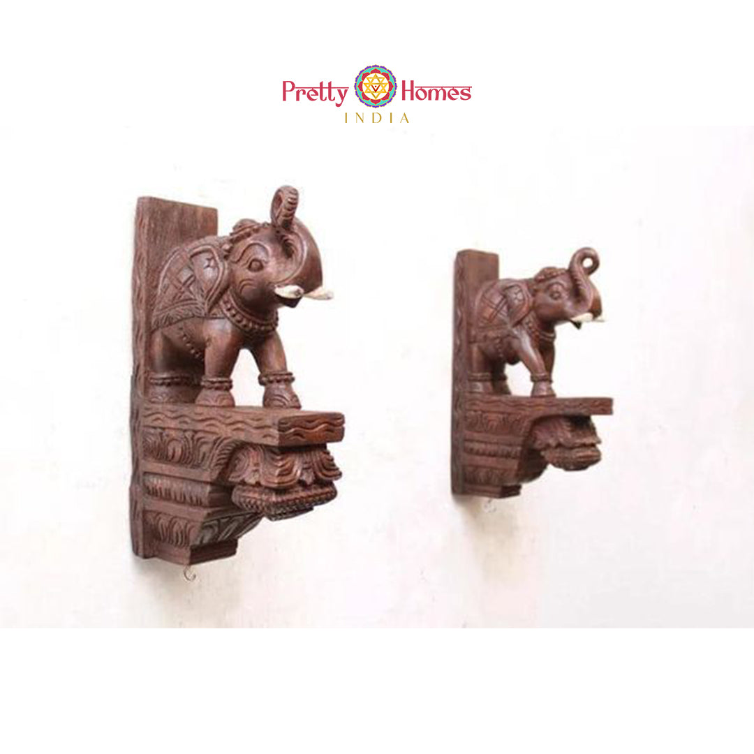 Set of carved wooden elephant wall corbels with detailed carving and hooks for hanging.