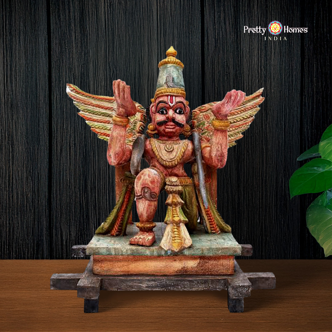 hand-carved wooden garuda statue on display base