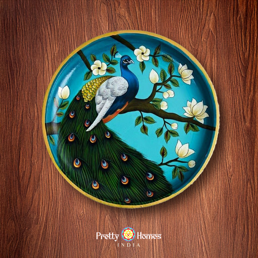 Handpainted wall plate with a peacock sitting on a tree branch, detailed floral background in pichwai style.
