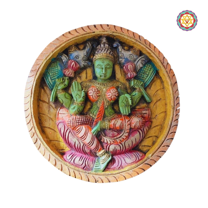 Gaja Lakshmi carved wooden panel with elephants, seated on lotus with upward palms
