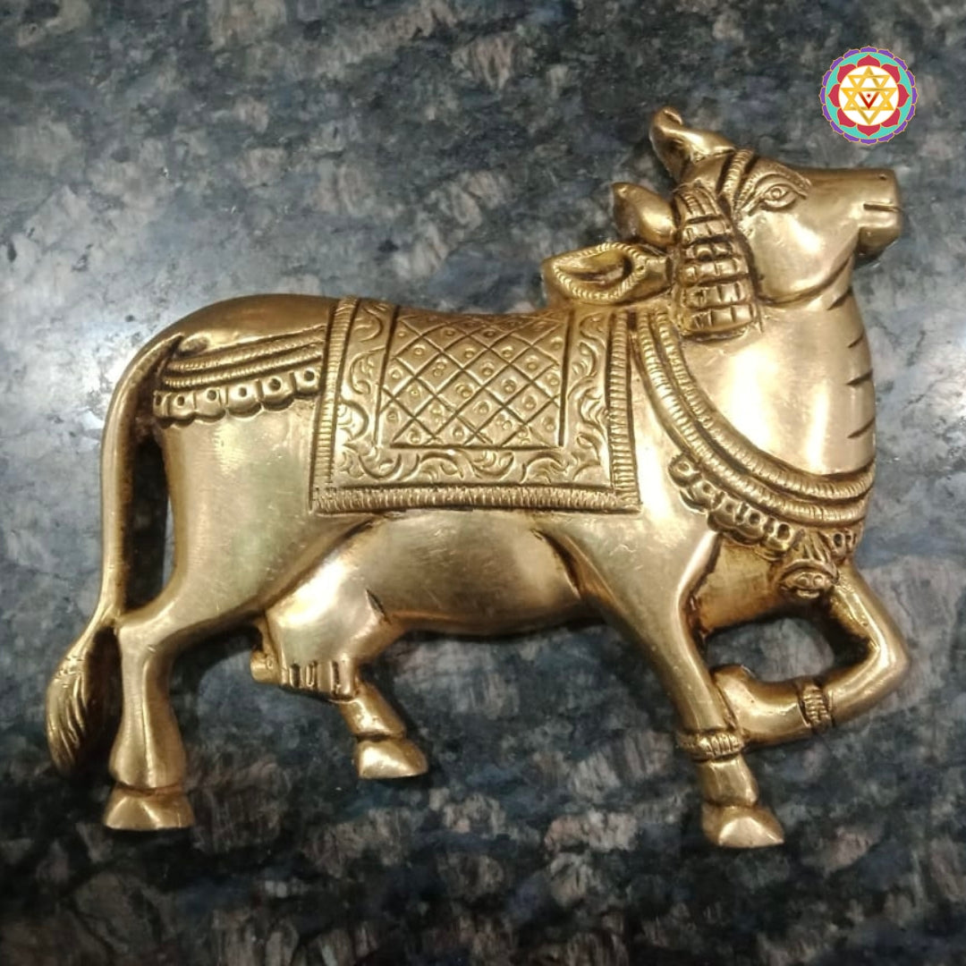 Brass wall hanging depicting cow with ornate floral design