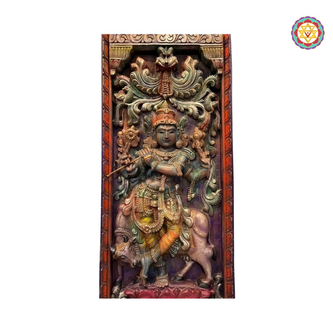 Decorative wall panel with a figure on a white background. Top-down close-up of Krishna wall carving in vertical panel

