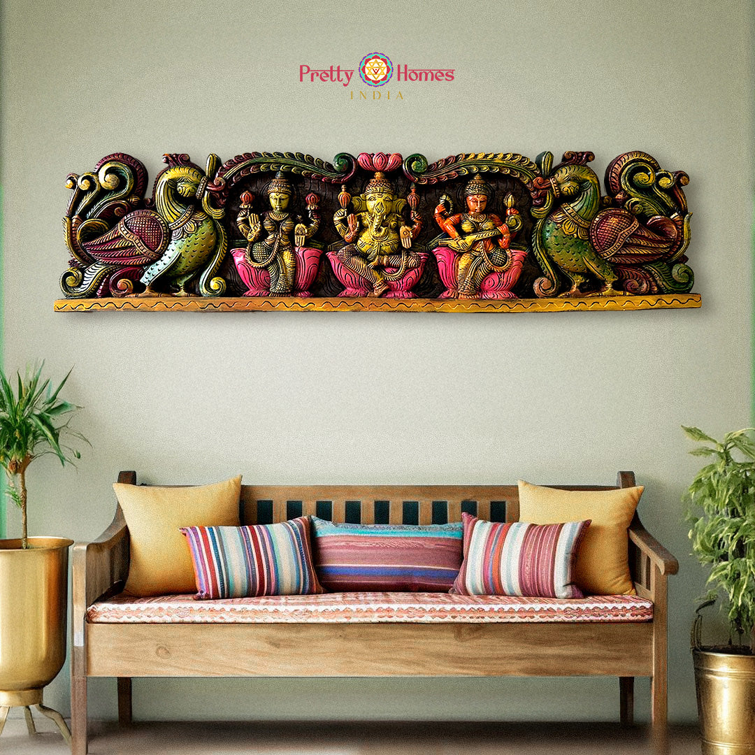 Decorative wall art with colorful figures above a wooden bench with striped cushions: Horizontal wooden wall panels with Ganesh, Laxmi & Saraswati in multicolour

