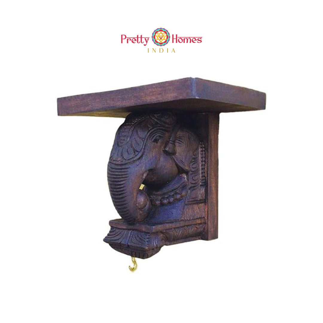 Solid carved elephant wall shelf with brass hanging hook and rich warm polish finish.