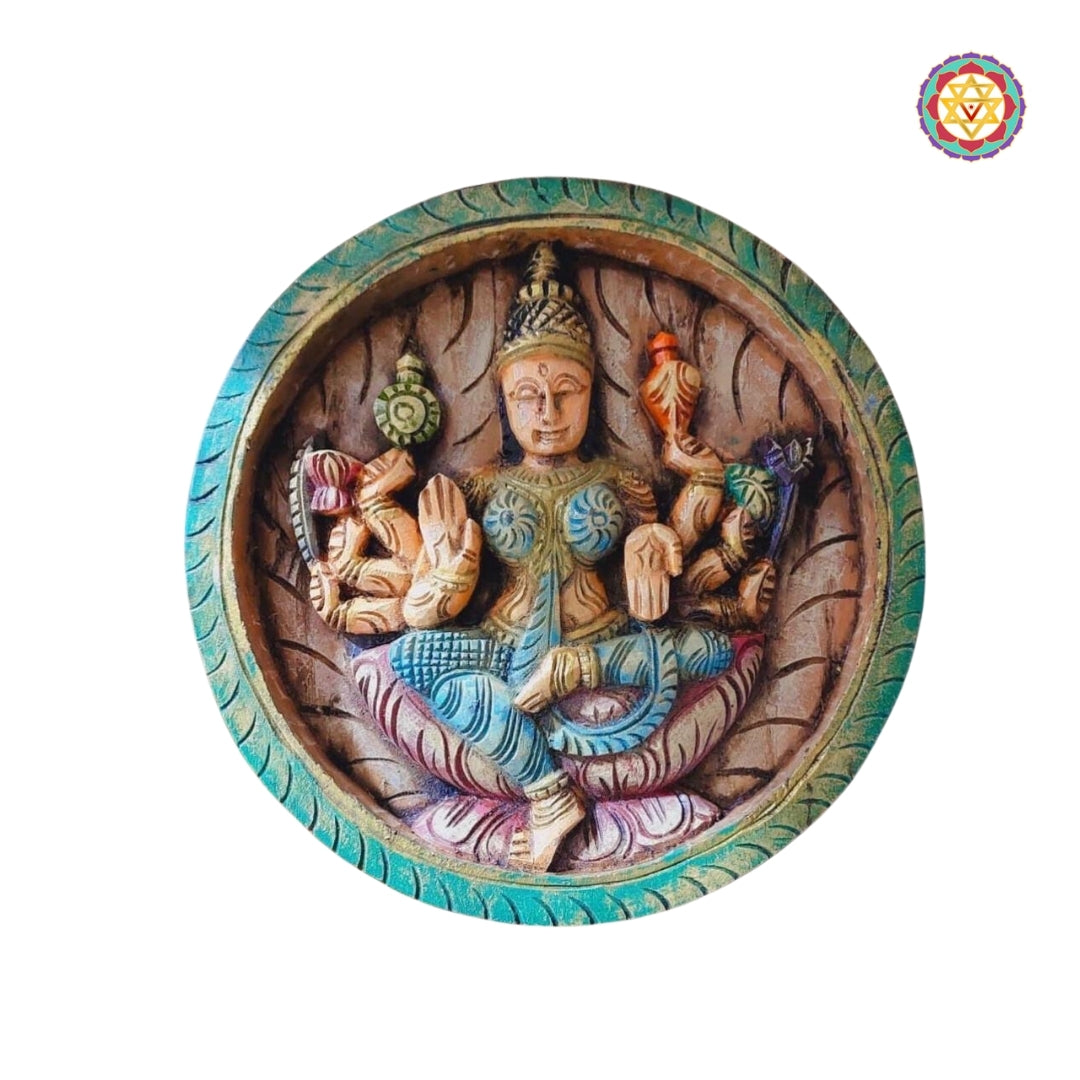 Dhairya Lakshmi panel with composed posture, shield and lotus motifs in wood carving
