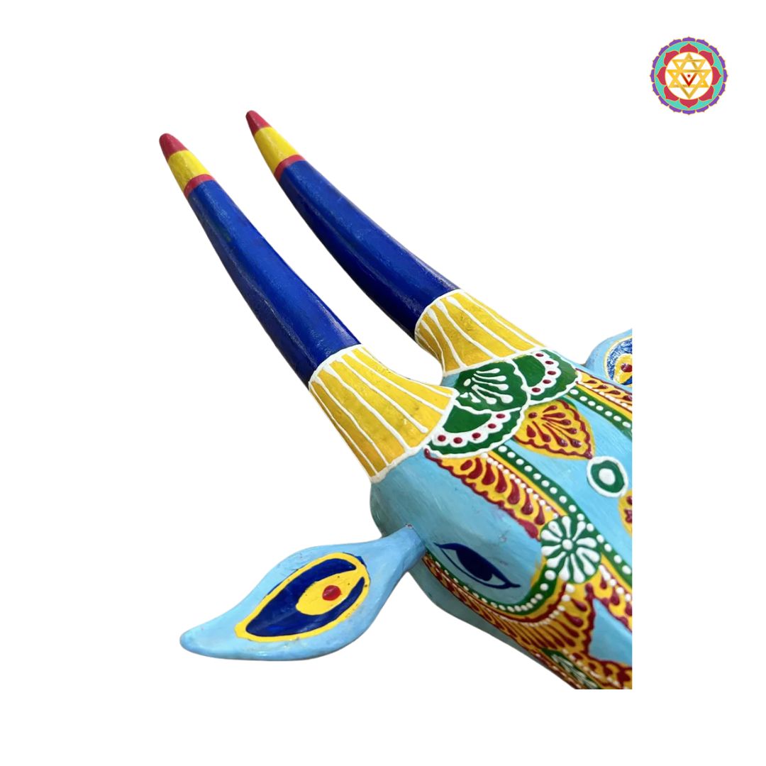 angled view of blue and yellow cow head wall mount showing painted patterns and sculpted texture