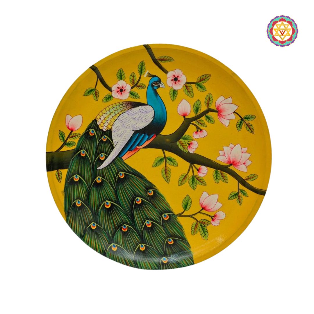 Yellow background wall plate with a handpainted peacock on a flowering branch.