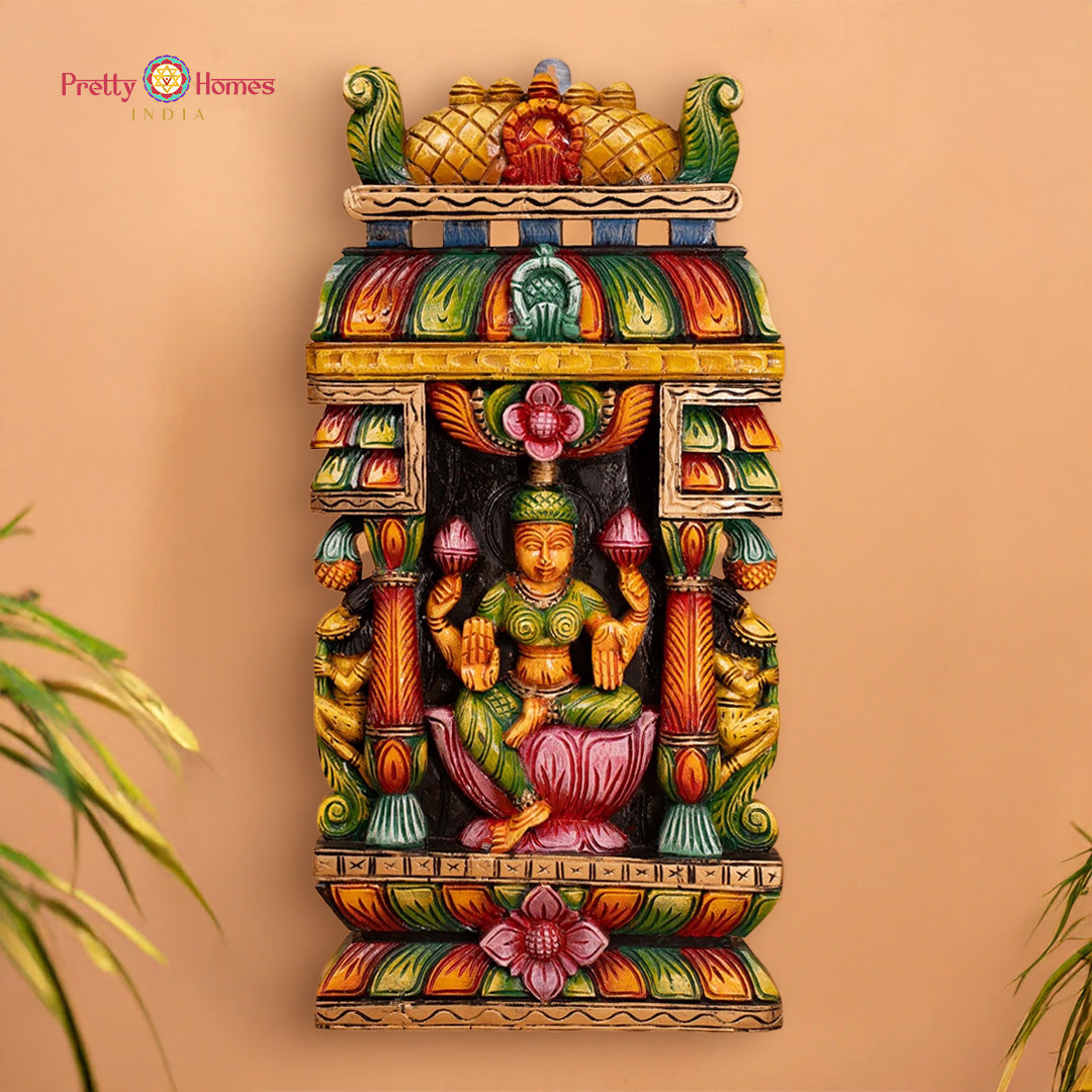 Colorful wall art with a deity figure on a beige background: Carved wooden wall panel of Goddess Laxmi with vibrant multicolour finish