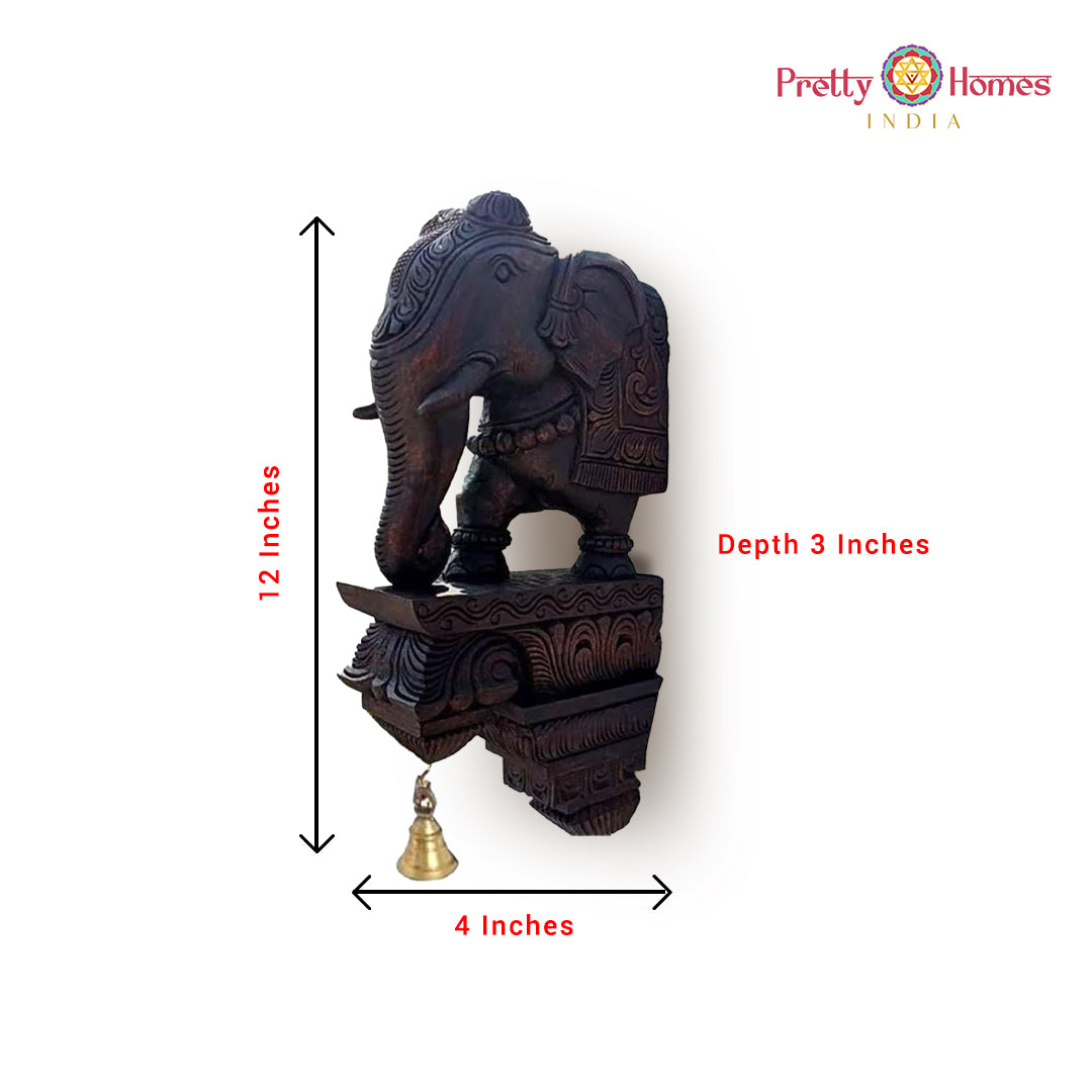 Carved wooden elephant corbel with hanging bell and product size markings (12 in height).