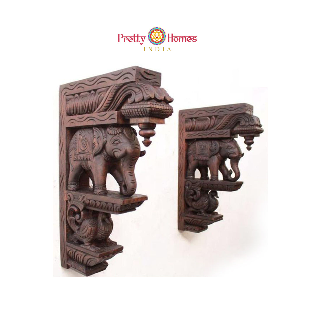 Set of large carved wooden elephant corbels with decorative finials and carved bird base.