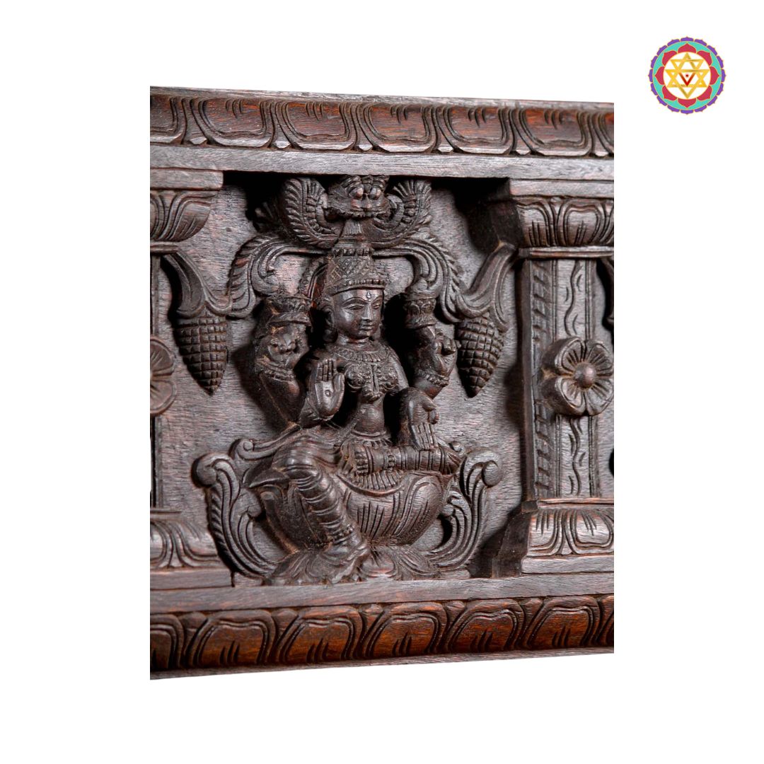 Detailed Lakshmi carving on wood wall panel
