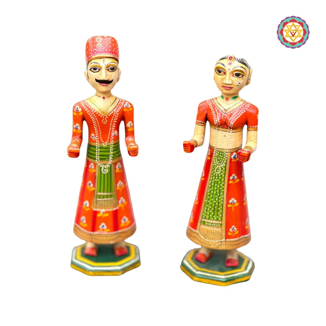 side view of wooden isar gangaur pair showcasing detailed attire and expressions