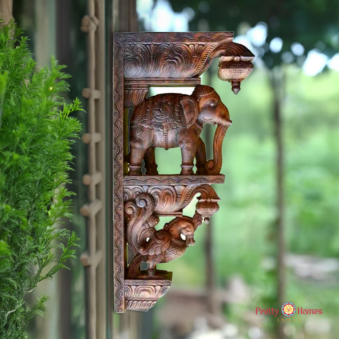 Decorative wall piece with elephant design against a blurred green background