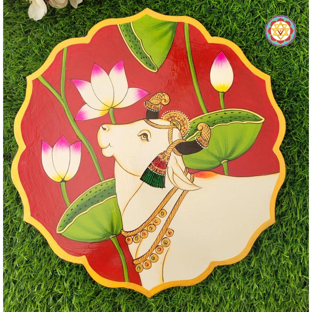 Pichwai cow painted wall plate with lotus pichwai painting on green petal base. A handmade pichwai painting for living room.