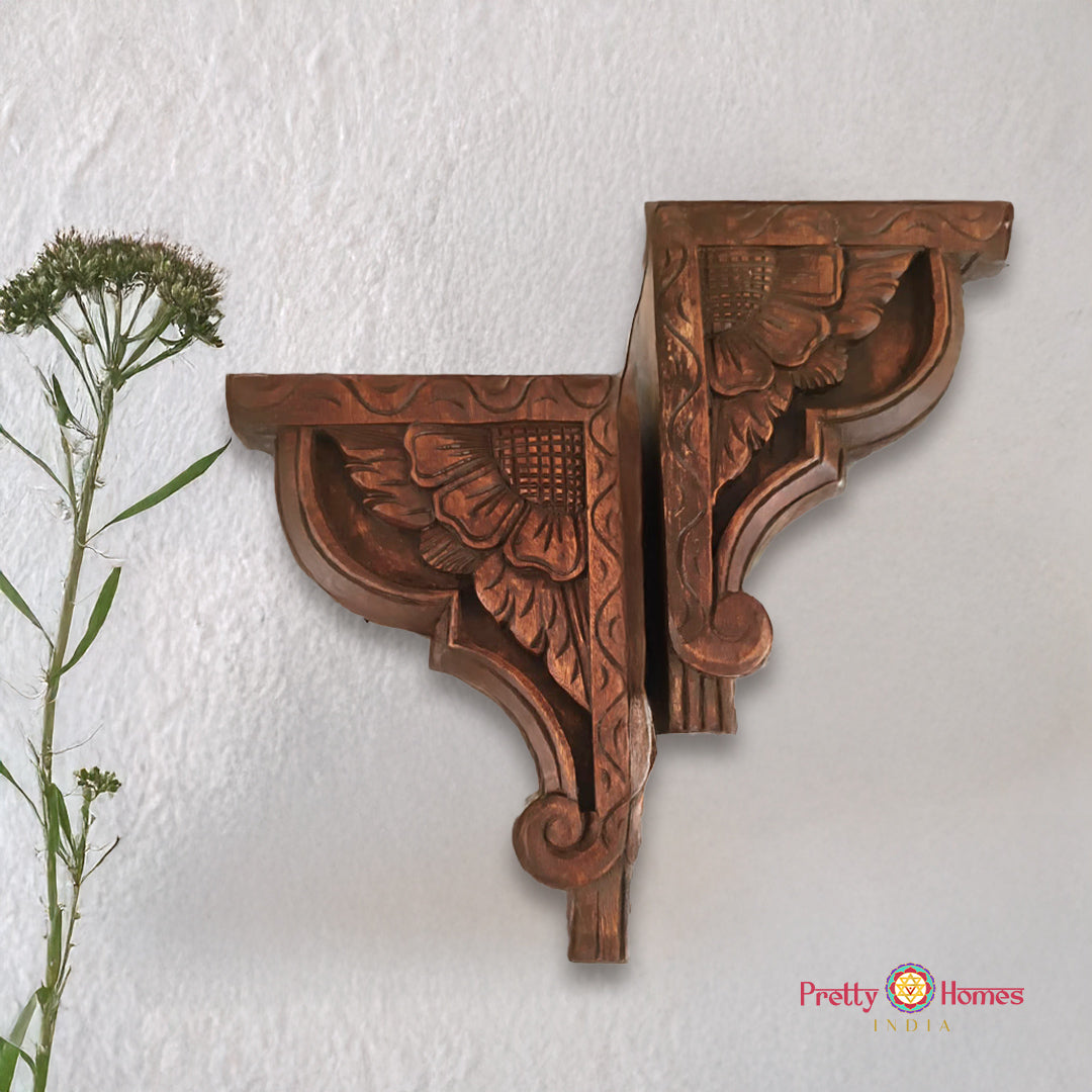 Decorative wooden brackets with floral carvings on a white wall, branded 'Pretty Homes'.