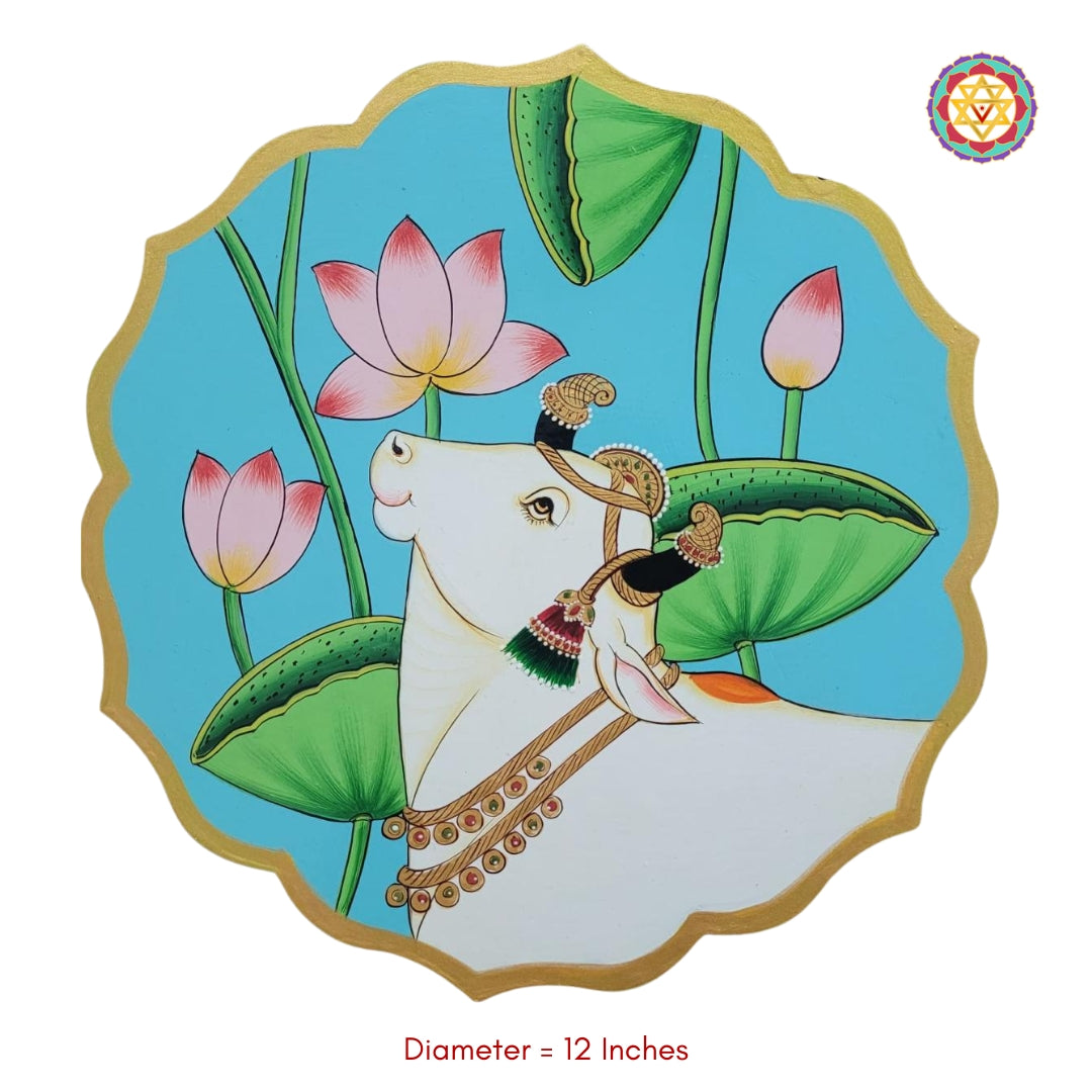 Studio image of pichwai cow wall plate with lotus pichwai painting. Decorative 12-inch wooden wall plate for pichwai wall art.