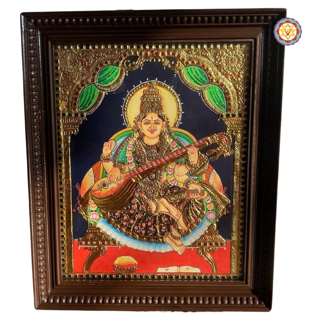 “Goddess Saraswati Tanjore art framed and angled, showing embossed gold detailing”
