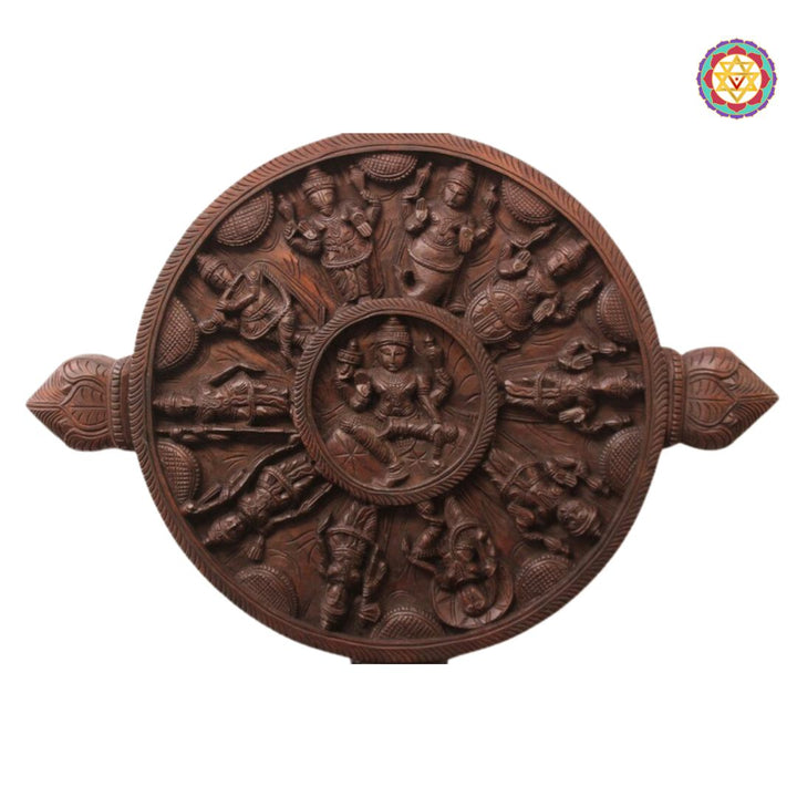 Wooden relief sculpture with intricate carvings on a white background. Close-up of Ashtalakshmi center on round Dasavatara wood panel.