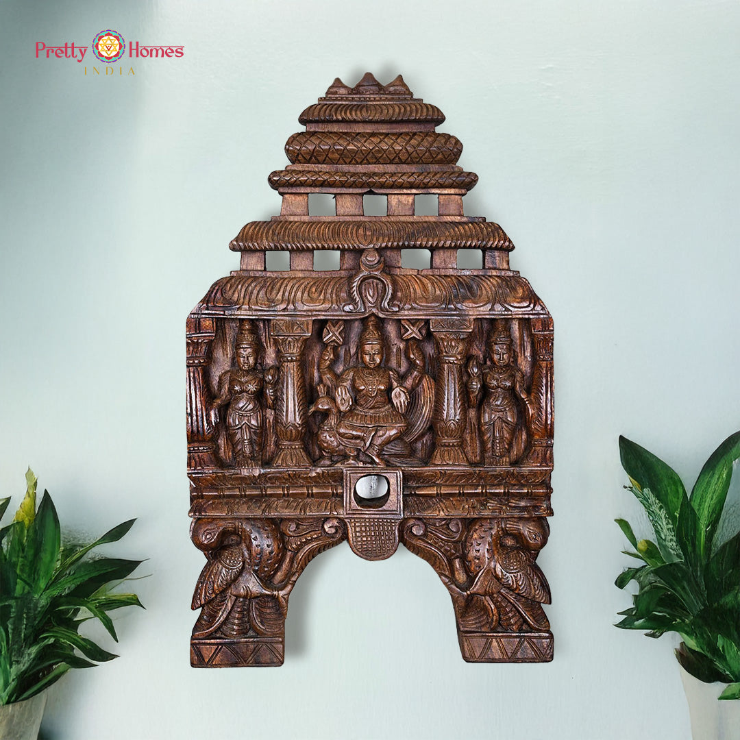 Carved wooden wall art with intricate designs on a light blue background. Kavadi panel with Lord Murugan, Valli & Deivanai in Chettinad carving

