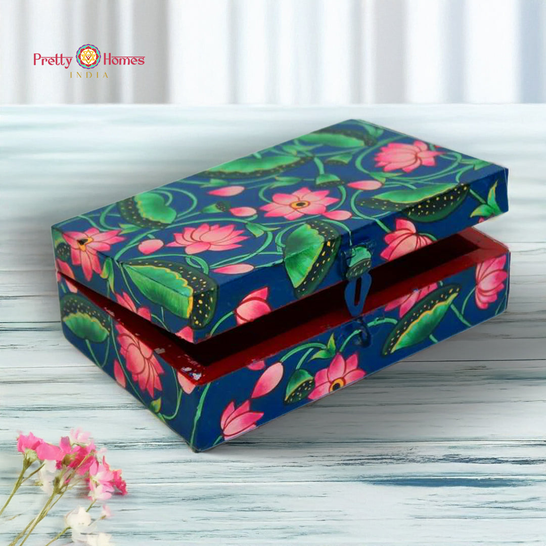 Medium cobalt blue Pichwai wooden box with hand-painted lotus and leaf artwork, placed on a textured surface.