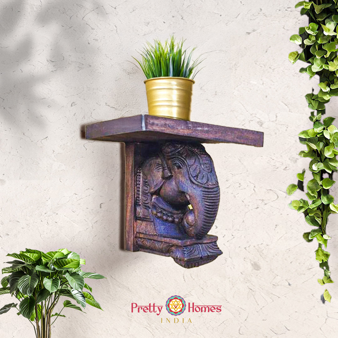 Wall-mounted carved wooden elephant shelf with flat top - ideal for small plants or idols.
