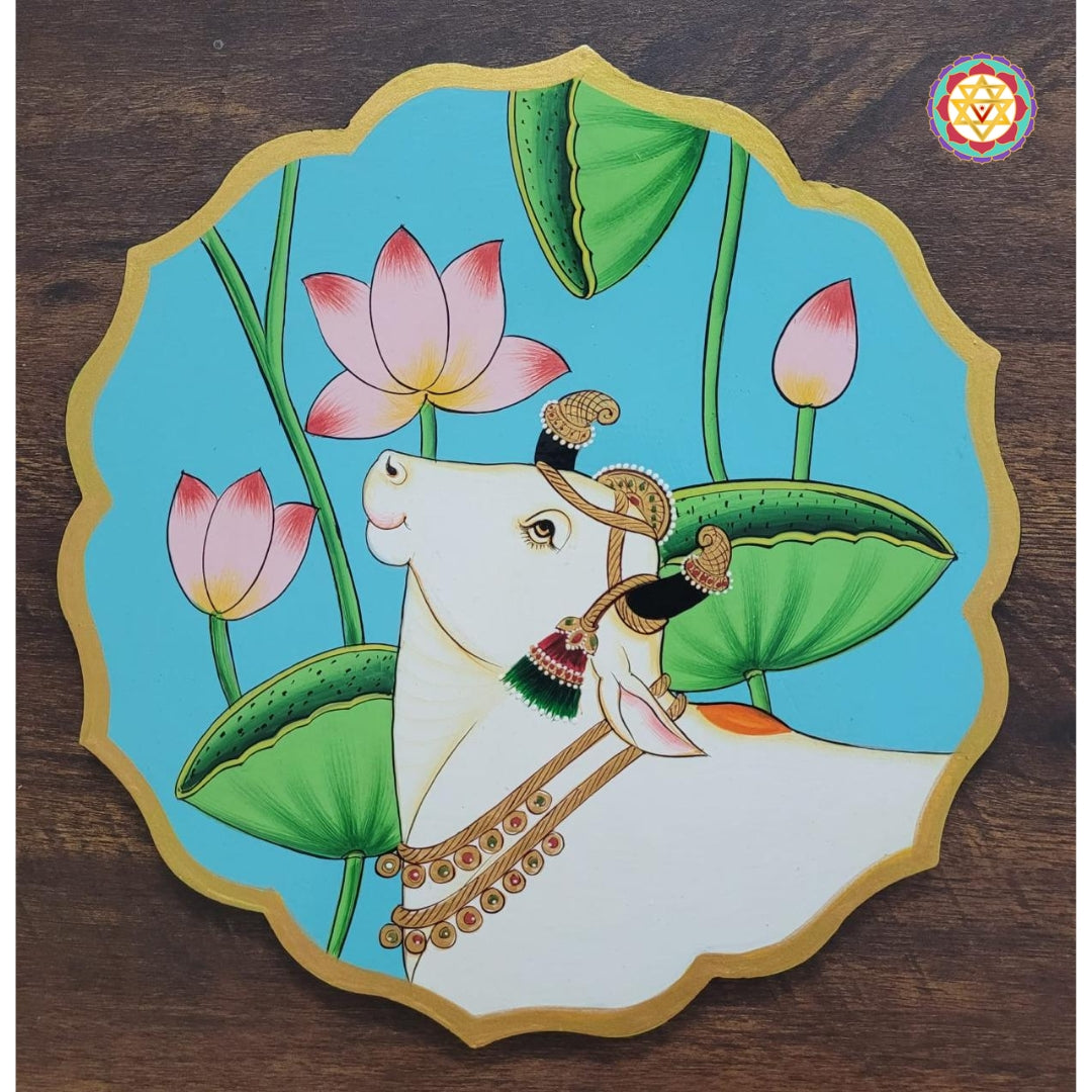 Angled shot of blue petal wall plate with pichwai cow and lotus artwork. A vibrant pichwai wall art accent.