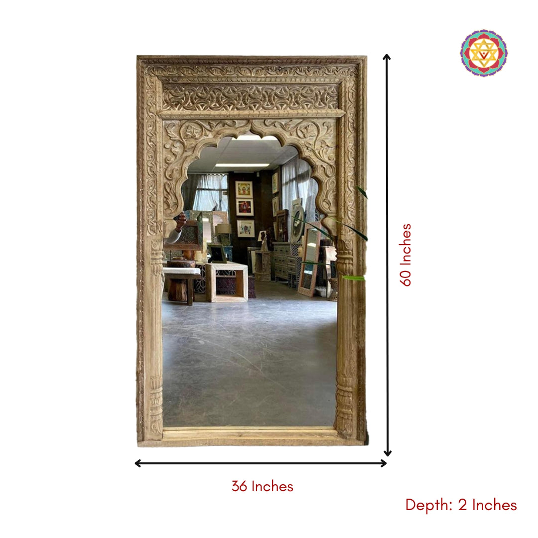“Natural wood finish wooden Jharokha mirror placed in an indoor living space.”