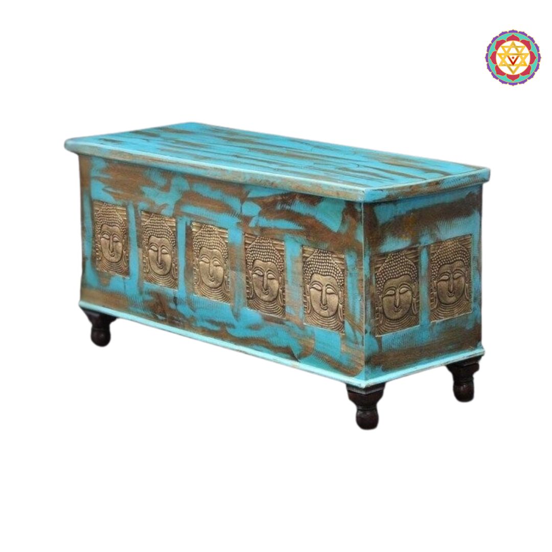 side view of wooden trunk coffee table with brass buddha accents