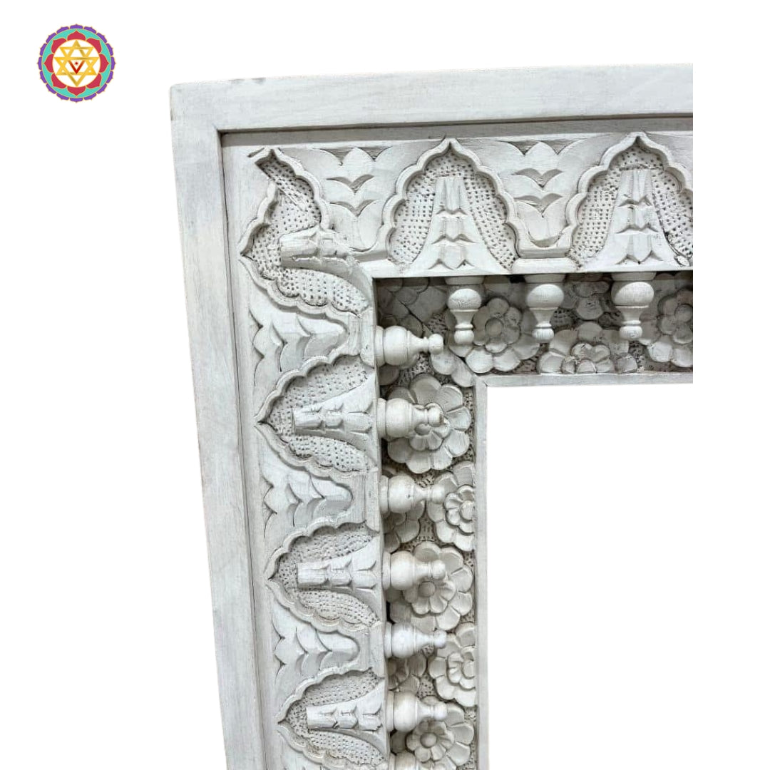 Close-up of hand-carved detailing on white frame