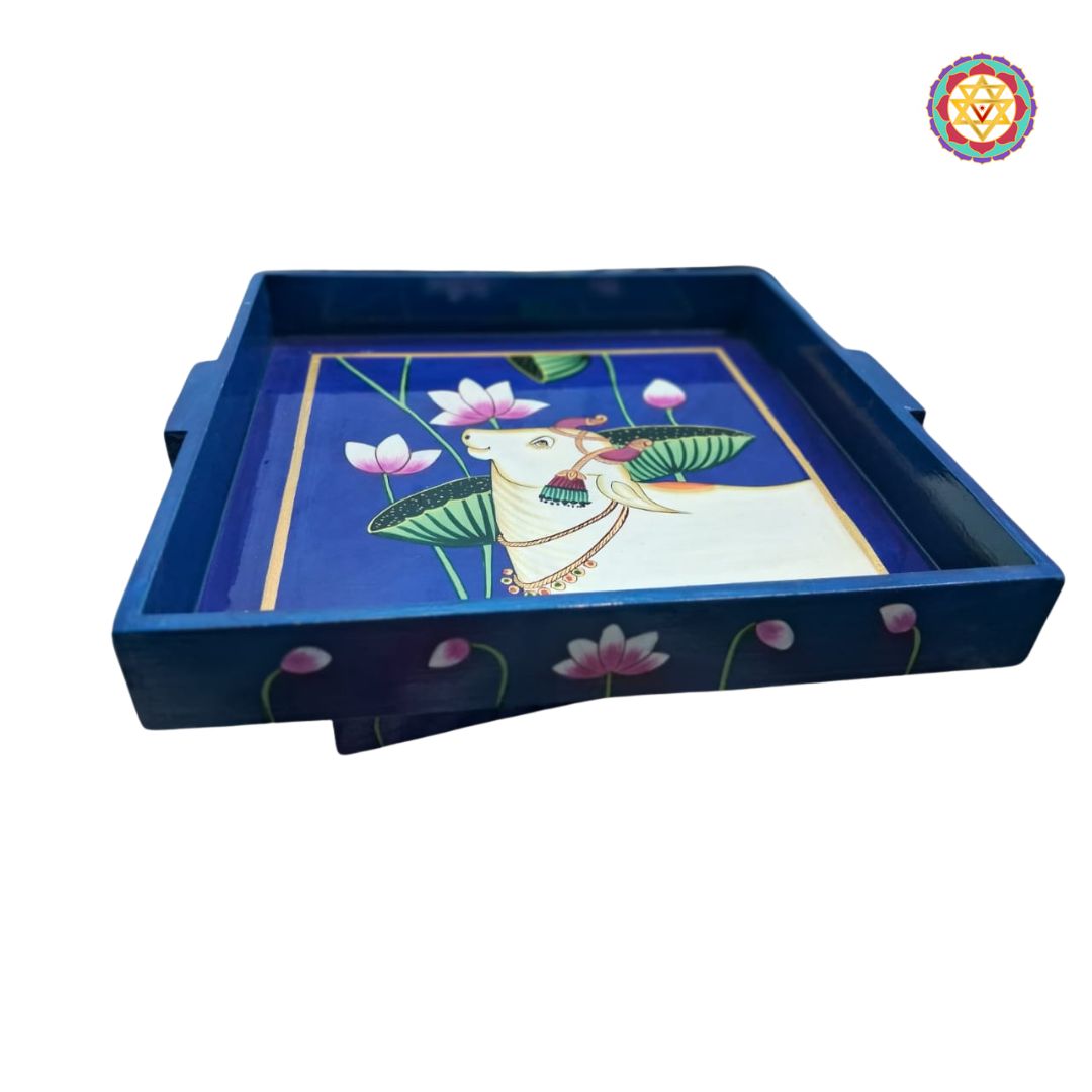 Side view of a traditional Pichwai-style cow serving tray in vibrant blue.