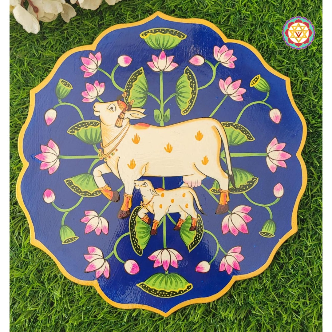 Blue wooden plate with pichwai cow and calf, designed in lotus pichwai painting style. Perfect for pichwai wall art lovers.