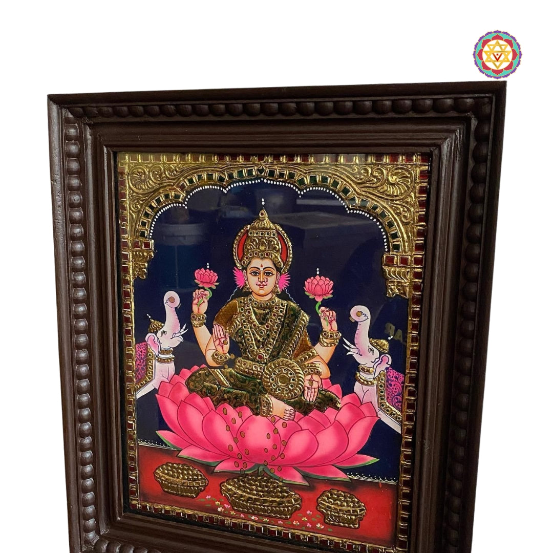 “Angled view of Gajalakshmi Tanjore painting with ornate gold detailing and wooden frame”