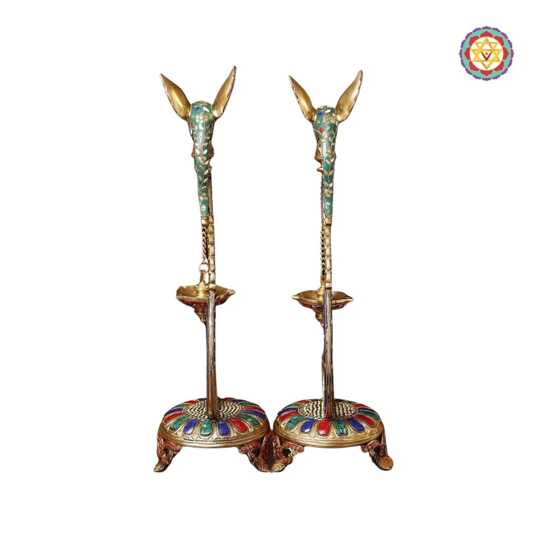 side-angle view of brass parrot diya highlighting elongated neck and sculpted feathers