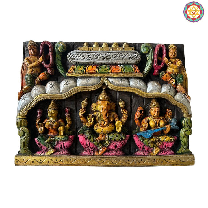 Decorative wall art with colorful statues on a white background. Front view of multicolour Ganesh Laxmi Saraswati wooden wall panel