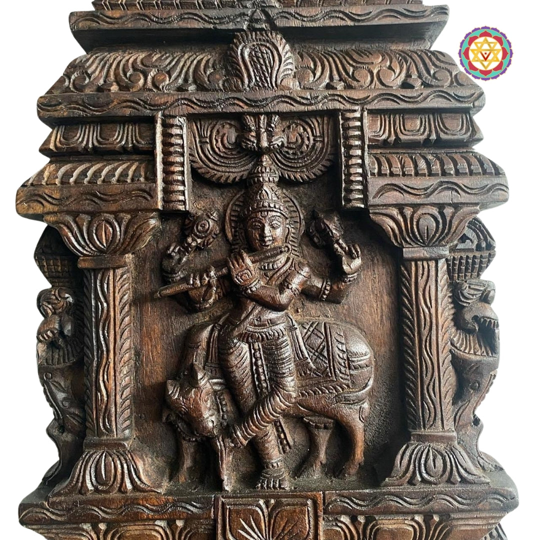 Carved wooden wall panel of Krishna with cow and flute
