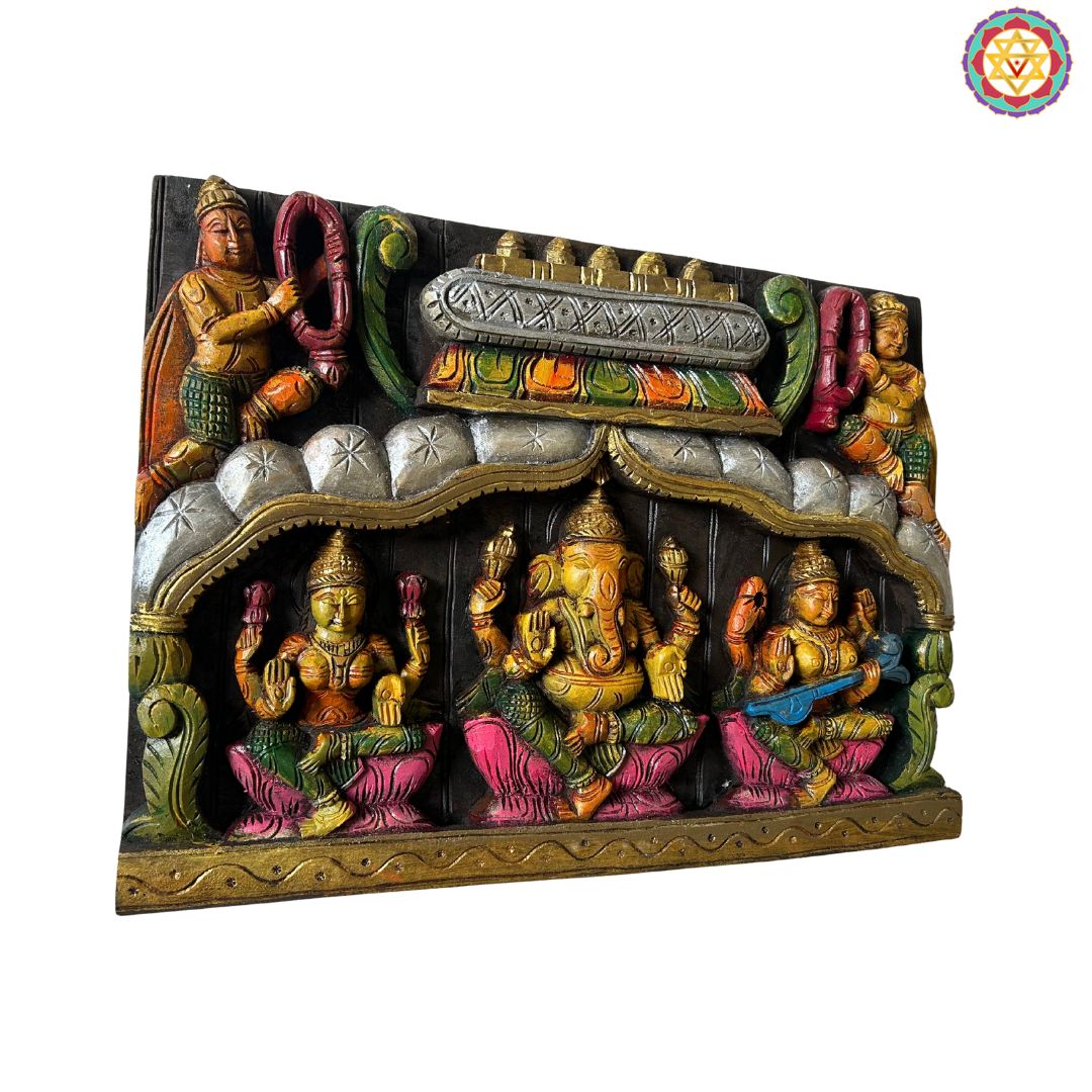 Decorative wall art with colorful figurines on a white background. Side view of intricately carved divine trio panel with garland motif