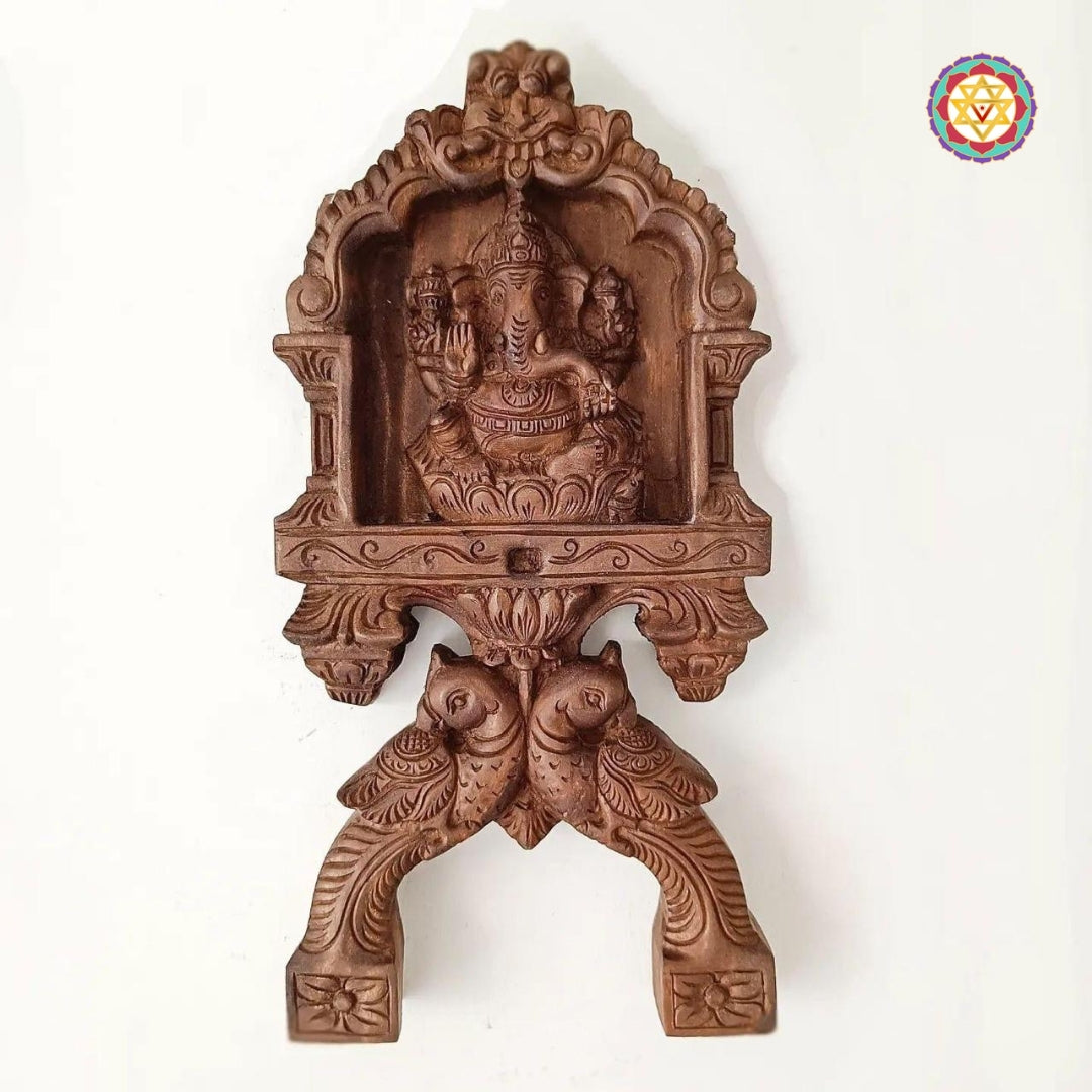 Woodcarved Ganesha & Laxmi kavadi style wall mounts with parrot carvings .