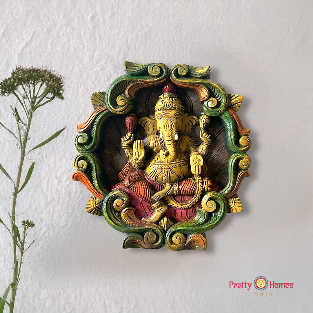 Colourful woodcarved ganesh wall frame with vines.