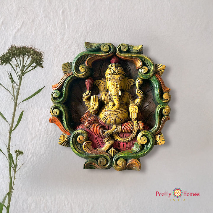 Colourful woodcarved ganesh wall frame with vines.
