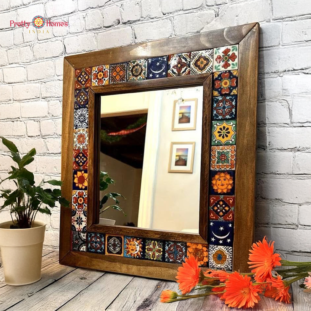 Wooden mirror with colorful ceramic tile frame placed near white brick wall